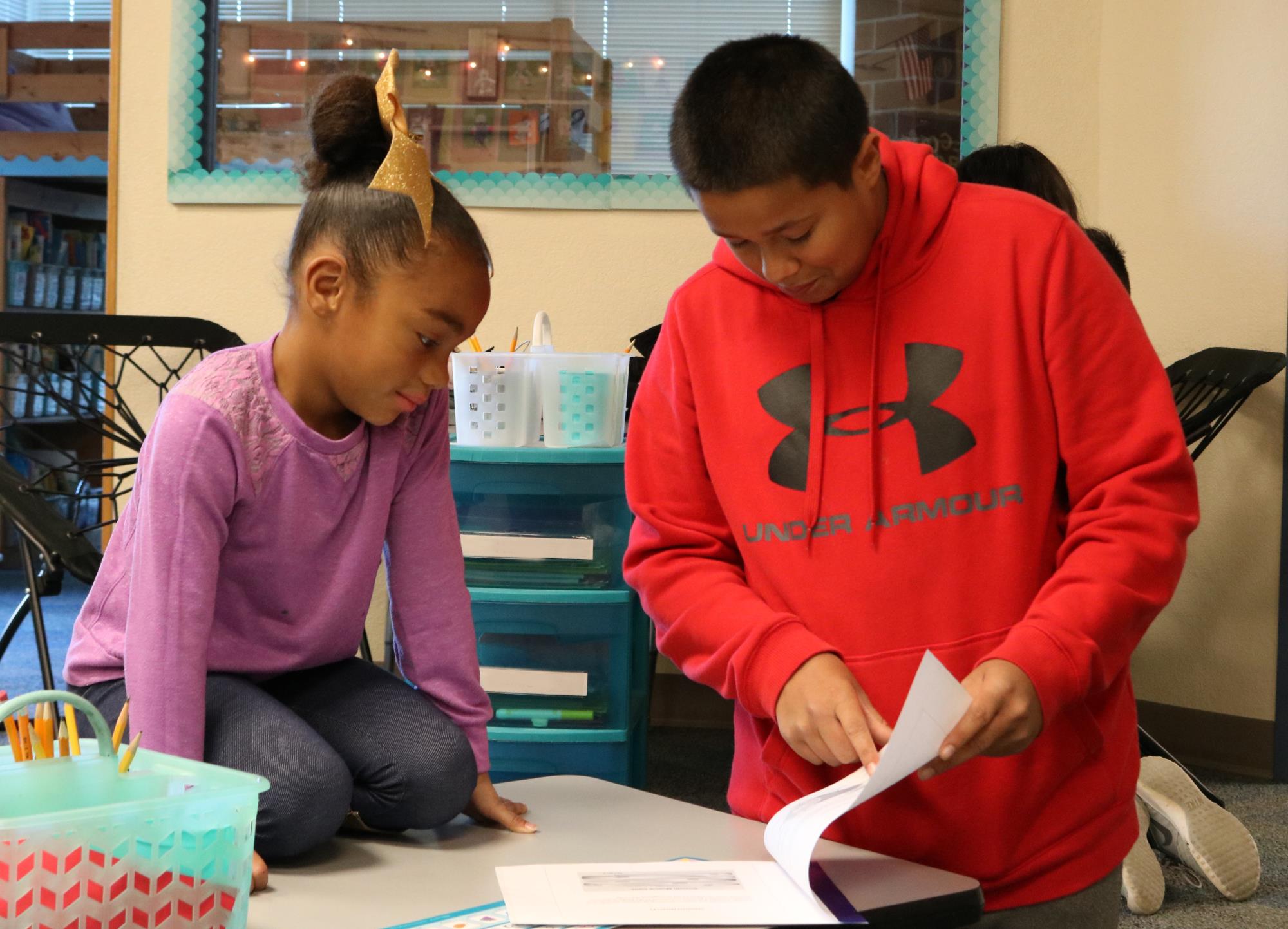 Middle school student reading to elementary student